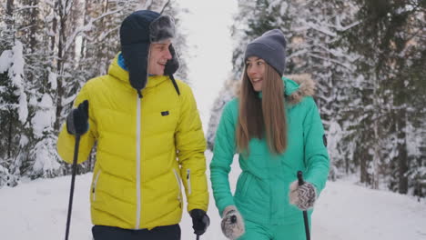 Loving-man-and-woman-in-slow-motion-in-winter-skiing-in-the-woods.-Valentine-day